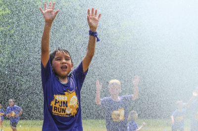 FEATURES: Leland elementary student Jordan Salinas enjoys some refreshing water courtesy of the Leland Township Fire Department during the 2023 Leland Fun Run. (June 8, 2023)  (Brian Freiberger | Leelanau Enterprise, Lake Leelanau, Michigan)