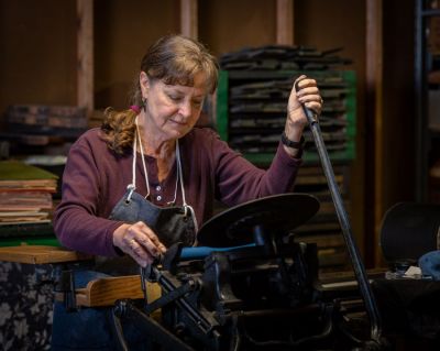 Rebecca Lawyer operates her vintage Chandler and Price Pilot tabletop press, which still works like a charm.